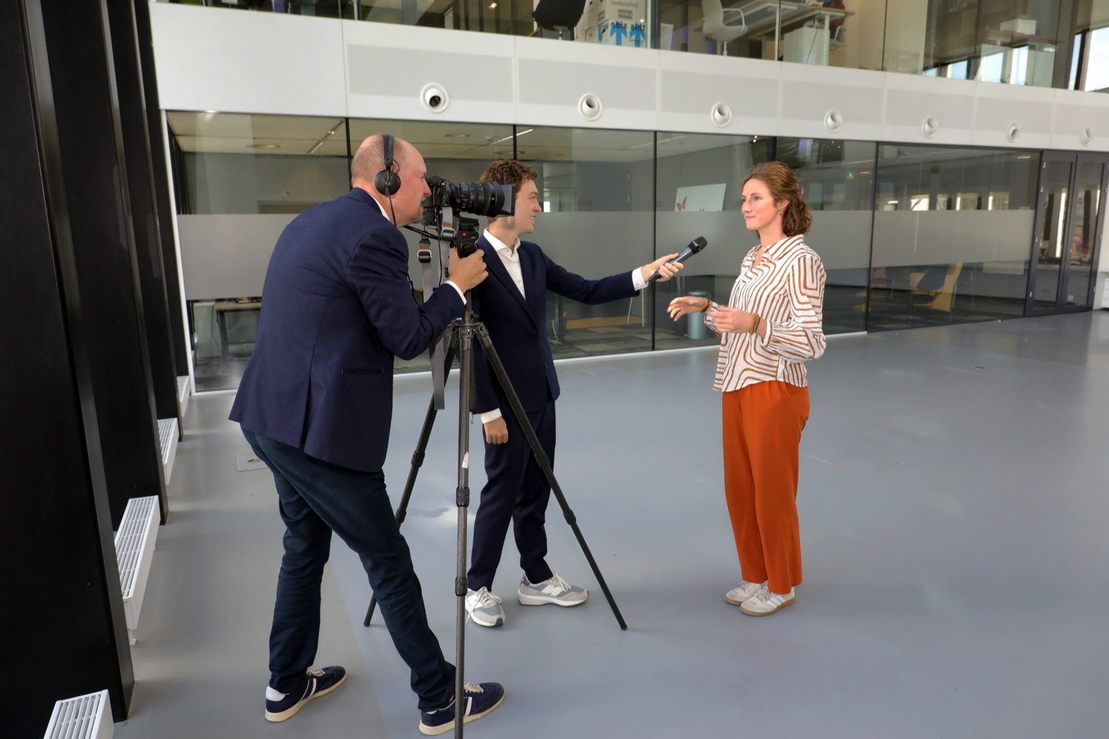 Cameraploeg neemt een congresfilmpje op met interviewer en presentatrice
